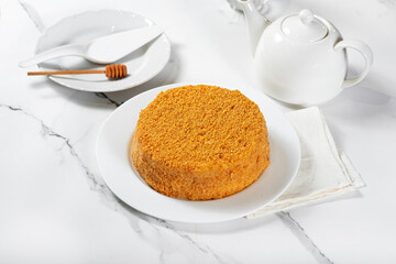 Honey cake on a white dish on a light table