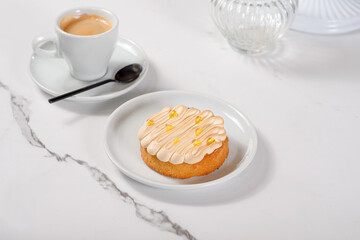 Fresh dessert on a white plate among white dishes with tea and coffee in a cafe