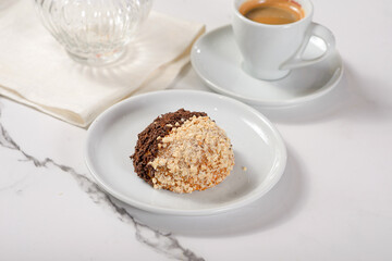 Fresh dessert on a white plate among white dishes with tea and coffee in a cafe