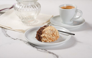 Fresh dessert on a white plate among white dishes with tea and coffee in a cafe