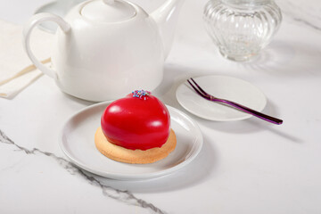 Fresh dessert on a white plate among white dishes with tea and coffee in a cafe