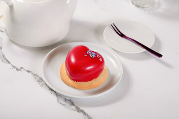 Fresh dessert on a white plate among white dishes with tea and coffee in a cafe