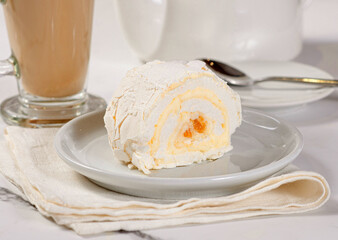 Fresh dessert on a white plate among white dishes with tea and coffee in a cafe