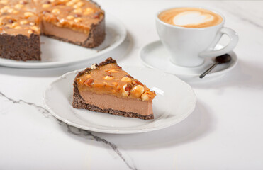 Fresh dessert on a white plate among white dishes with tea and coffee in a cafe