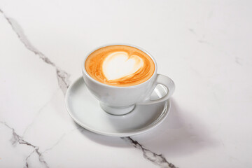 Cup with cappuccino on light marble table