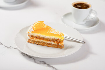 Fresh dessert on a white plate among white dishes with tea and coffee in a cafe