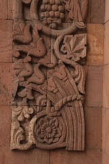 Bas-relief on the wall of a building in Yerevan, made according to floral motifs and natural stone - pink tuff.