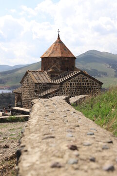 One of the temples in the ancient Sevanavank monastery on Lake Sevan in Armenia and part of the monastery wall leading to the temple.