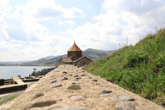 One of the temples in the ancient Sevanavank monastery on Lake Sevan in Armenia and part of the monastery wall leading to the temple.