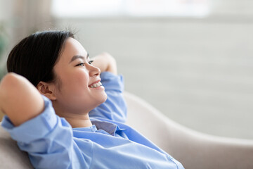 Cheerful young asian lady enjoying weekend at home