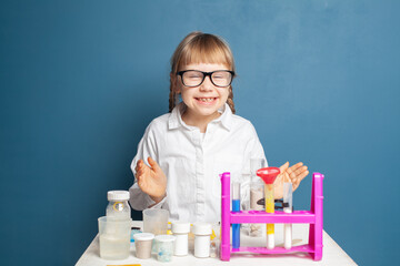 Laughing child student studying science and laughing on blue background