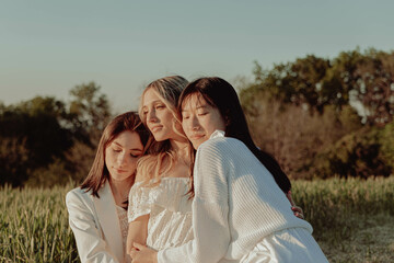 Embrace of three girls in countryside.