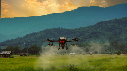 smart farming innovation, agriculture drone fly spraying fertilizer on green rice field in countryside of Thailand, agricultural industrial technology
