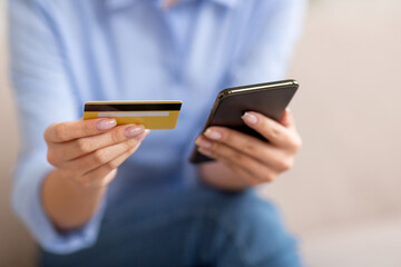 Unrecognizable lady holding cell phone and credit card