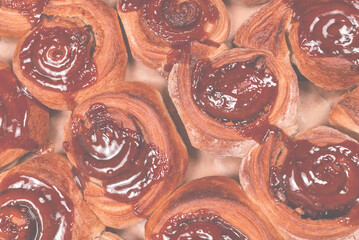 Homemade cinnamon buns with spices and caramel on parchment paper.