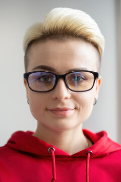 Beautiful tomboy person portrait. Cheerful white woman with dyed short hair wearing nerd glasses