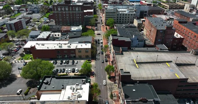 Urban city in USA on sunny day. Aerial tilt up reveal above street traffic.