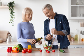 Attractive mature man and woman cooking together at home