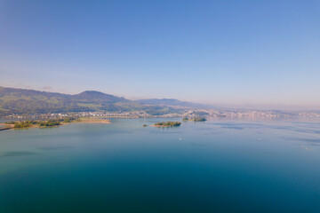 Fototapeta premium Aerial view from City of Rapperswil-Jona with Lake Zürich and two islands on a sunny spring day. Photo taken April 28th, 2022, Raperswil-Jona, Canton St. Gallen, Switzerland.