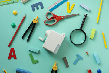 Different stationery on green table background, flat lay. Space for text, back to school concept