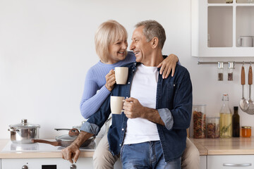 Loving elderly couple enjoying morning coffee at home