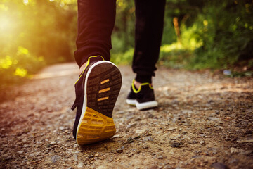 Close up shot of runner's shoes. Man running at autumn during sunrise. Closeup shot of a sporty man...