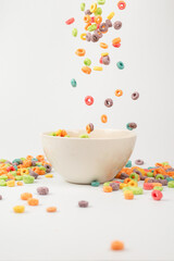 Colorful cereal box for morning breakfast. Corn flakes falling to the white bowl. Motion.