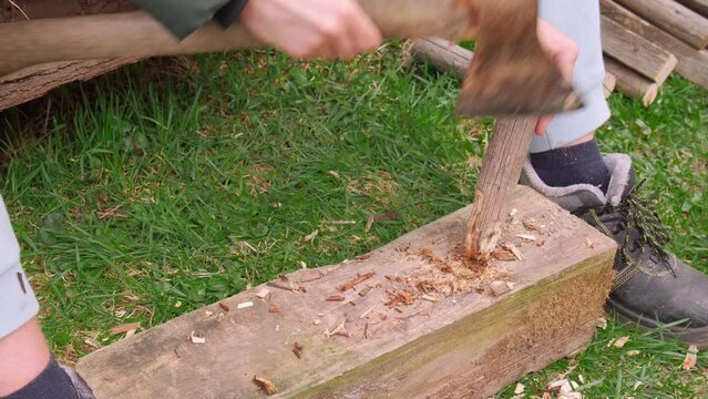 A man sharpens sharp stakes with an iron axe 