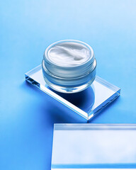 Face cream moisturiser jar on glass and blue background, beauty product and skincare, cosmetic...