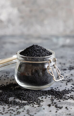 Fototapeta na wymiar Indian spice Black cumin (nigella sativa or kalonji) seeds in glass jar close up