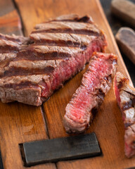 Grilled beef fillet steak with herbs and spices on dark table close up