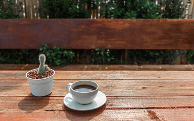cup of coffee on wooden table in morning sun