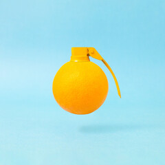 Minimal composition with fresh orange fruit and bomb fuse against pastel blue background.  Creative...
