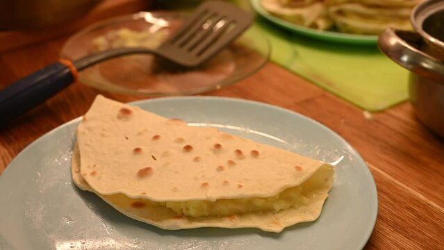 Filling flatbreads with mashed potato. Cooking traditional dish of tatar cuisine - qistibi