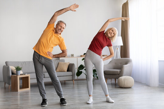 Positive mature couple having workout at home