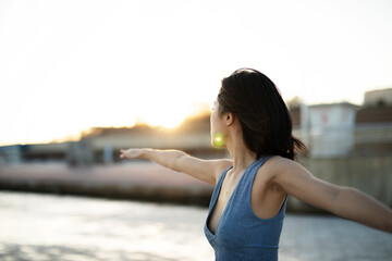 Beautiful young woman stretching outside. Fit woman doing yoga exercise.