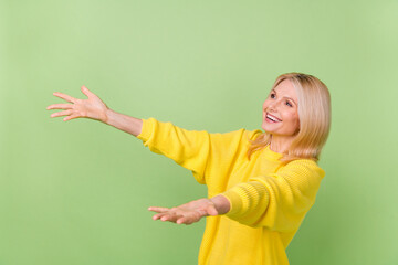 Photo of excited aged lady try catch advert bargain fall down empty space isolated on green color background