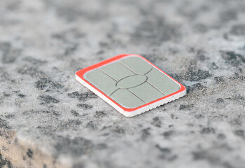 a nano SIM card for a mobile phone or smartphone lies on a stone surface