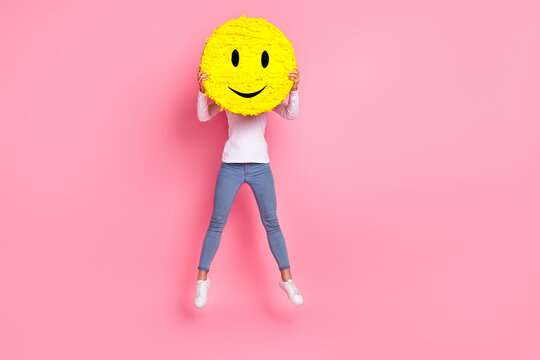 Full length photo of funky young lady jump hold smile wear shirt jeans footwear isolated on pink background