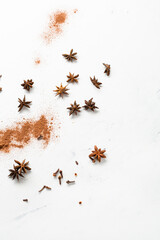 Spice powder and anise star cinnamon clove on light surface