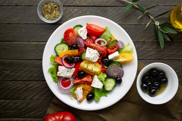 Overhead view of Greek salad on wooden background