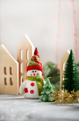 Snowman and wooden houses winter holiday concept