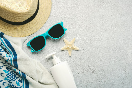 Summer holiday concept.Top view of beach towel,sunglasses,hat and sunscreen with space for text