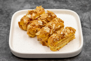 Cream eclairs cake. Eclair cake with cream filling on a dark background. close up