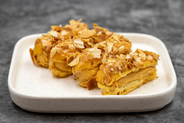 Cream eclairs cake. Eclair cake with cream filling on a dark background. close up