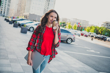 Portrait of attractive confident cheerful girl carrying laptop drinking latte spending sunny day strolling outdoors