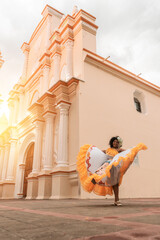 Vertical photo of a curly-haired mestizo traditional dancer with a typical Nicaraguan costume dancing outside the cathedral of Leon Nicaragua celebrating the independence festivities