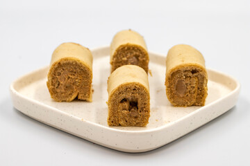 Roll cake with hazelnut and chocolate filling. roll cake on a white background. close up