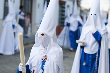 Spanish Holy Week processions with people wearing white, traditional capirotes