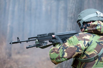 military man aiming with a rifle in the forest